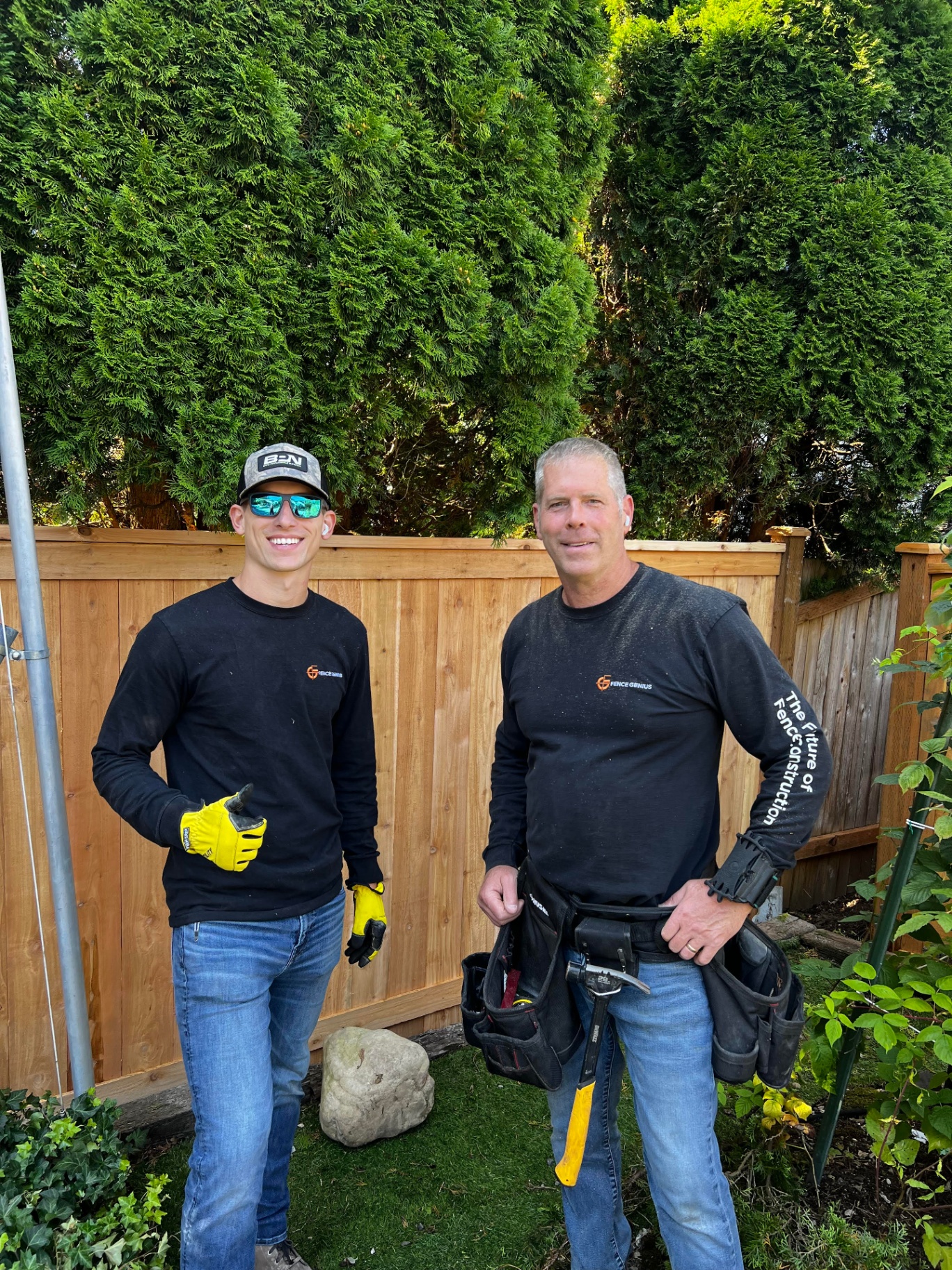 Father and son team at MyFence.com standing in front of a cedar fence in Seattle